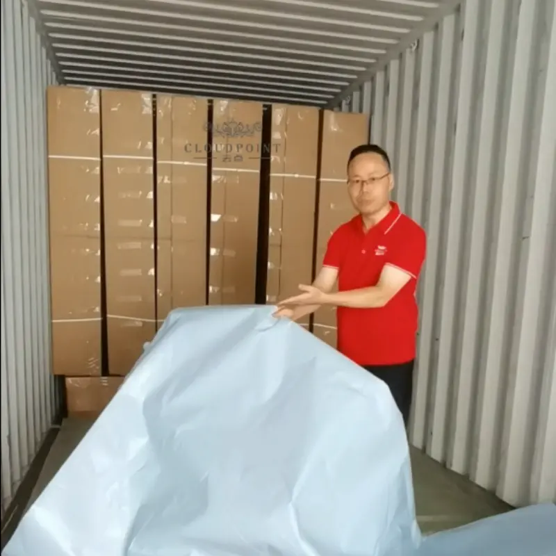 Container loading is in progress at the mattress factory.